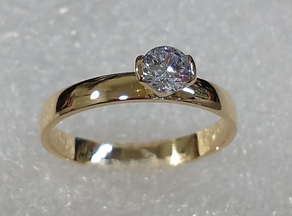 Anillo solitario en oro amarillo con piedra redonda, vista de lado